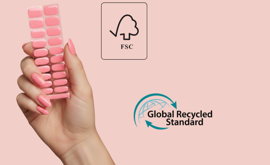 Hand holding Gel Nail Wraps with FSC and Global Recycled Standard logos on a pink background