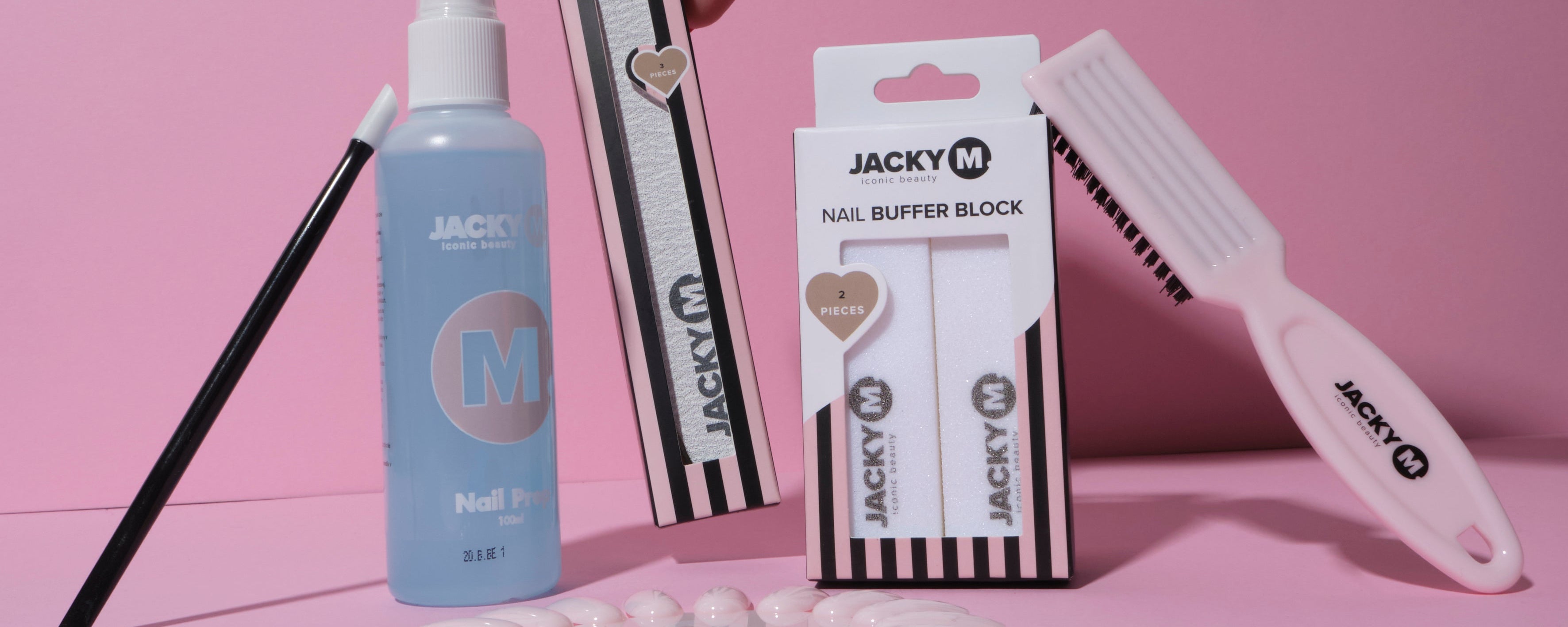 JACKY M nail prep tools including nail file, buffer block and brush on pink background