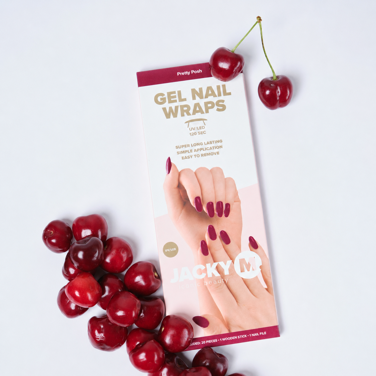A package of cherry-flavored gel nail wraps by Jacky Q is displayed on a clean white background, styled with fresh red cherries. The box features a pink and burgundy design with an image of manicured nails painted in a deep cherry red.
